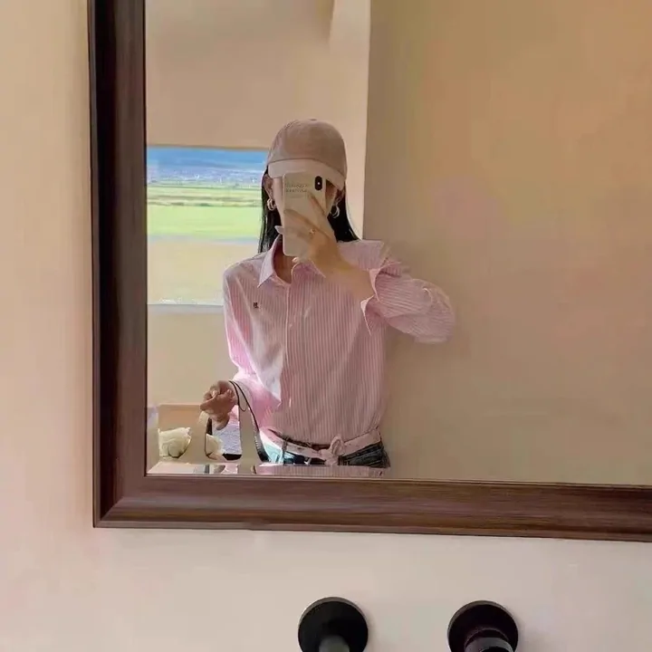 A person wearing a pink shirt in a mirror photograph